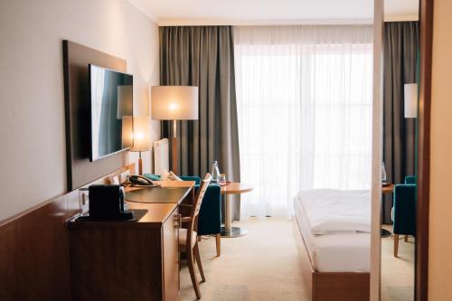a hotel room with a desk and a bed at Klostermaier Hotel & Restaurant in Icking