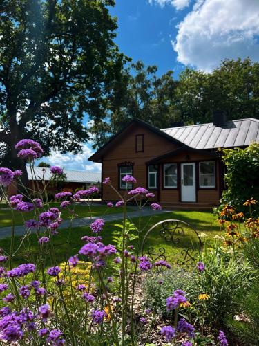a garden with purple flowers in front of a house at Vilties vila in Anykščiai