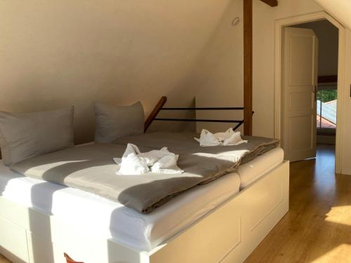 a bed with white sheets and pillows on it at Zum Ilmwinkel in Bad Sulza