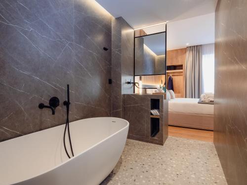 a bathroom with a bath tub and a bedroom at Space Row Design Living in Heraklio Town