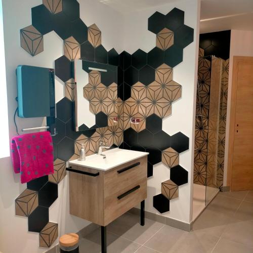 a bathroom with a black and white wall with a sink at L'Ecrin de 40m2 pour 2 personnes in Eygliers