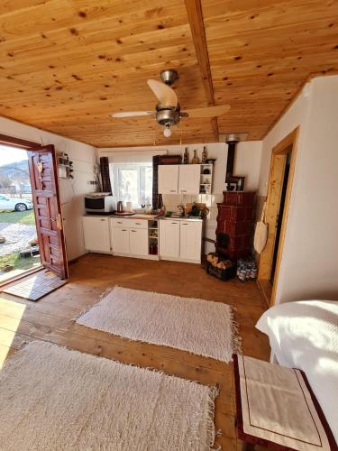 a kitchen with white cabinets and a wooden ceiling at La Andrei in Taşca