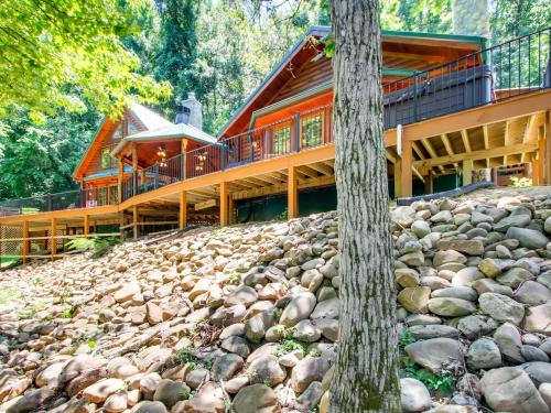 una grande casa di legno in cima a una collina rocciosa di A River Adventure #4237 a Pigeon Forge