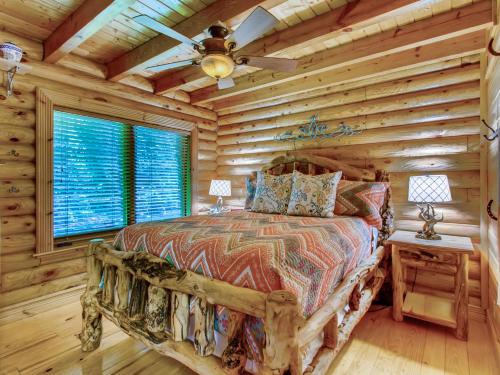 una camera con un letto in una baita di tronchi di A River Adventure #4237 a Pigeon Forge