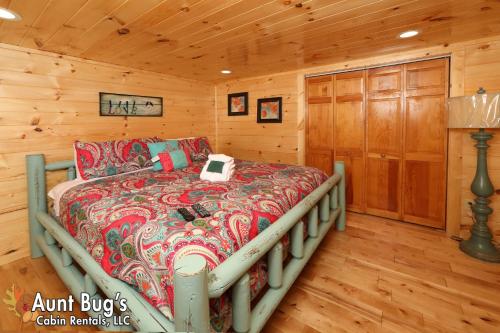 a bedroom with a bed in a log cabin at A Secluded Retreat #216 in Pigeon Forge