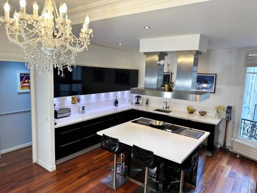 une grande cuisine avec un lustre et une table dans l'établissement Appartement spacieux Arc de Triomphe Paris, à Paris