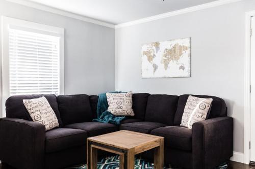 a living room with a black couch and a table at Winnetka Heights Hideaway in Dallas