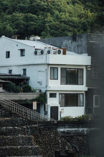 a white house sitting on the side of a hill at Sweetfun in Ruifang