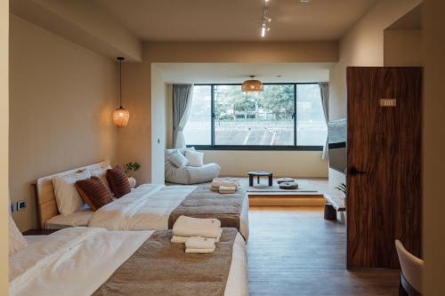 a bedroom with two beds and a large window at Sweetfun in Ruifang