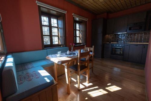 a living room with a table and a kitchen at Tis Ouranias in Koukouli