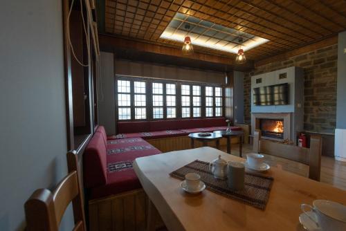 a living room with a table and a fireplace at Tis Ouranias in Koukouli