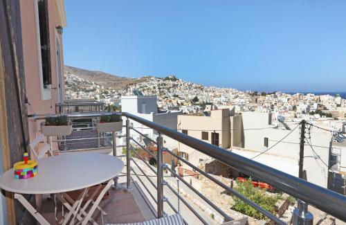 a balcony with a table and a view of a city at Virginia's guest house in Ermoupoli
