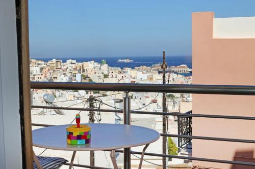 a table on a balcony with a view of a city at Virginia's guest house in Ermoupoli