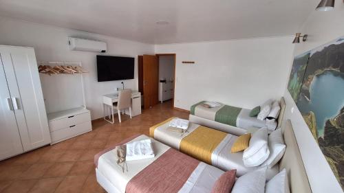 a living room with two beds and a flat screen tv at A Caminho da Ilha in Ponta Delgada