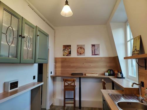 une cuisine avec des armoires vertes et un évier dans l'établissement logement de charme 2 chambres 100m2 hypercentre 2ème étage, à Nemours