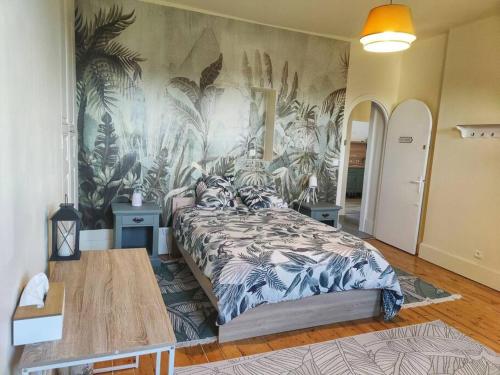 une chambre avec un lit avec un papier peint tropical dans l'établissement logement de charme 2 chambres 100m2 hypercentre 2ème étage, à Nemours