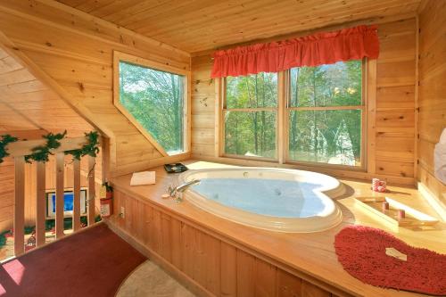 a large bathroom with a tub in a log cabin at Always Misbehavin #1412 in Gatlinburg