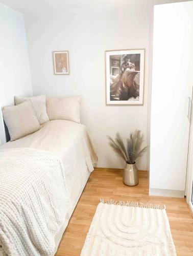 a white bedroom with a bed and a rug at Moderne leilighet midt i Stavanger sentrum in Stavanger