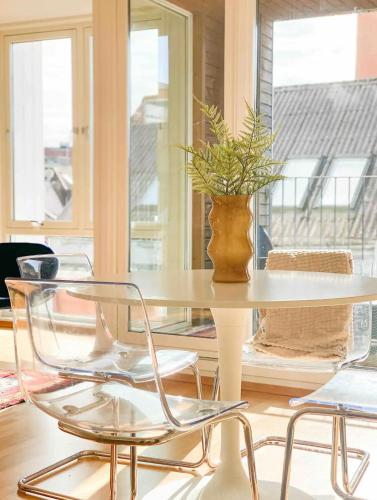 a table and chairs with a vase on top of it at Moderne leilighet midt i Stavanger sentrum in Stavanger