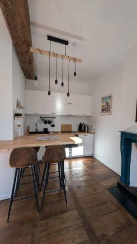- une cuisine avec deux chaises et une table dans une chambre dans l'établissement App 24 Appartement de caractère, à Vitré