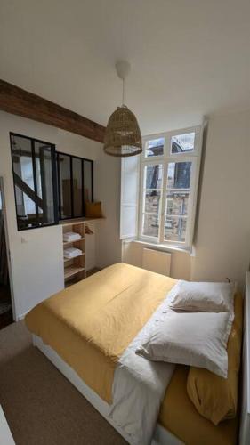 une chambre avec un lit et deux fenêtres dans l'établissement App 24 Appartement de caractère, à Vitré