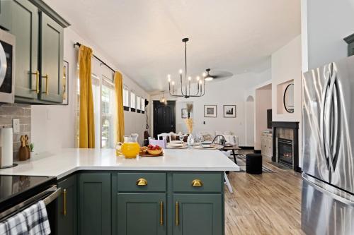 a kitchen with green cabinets and white counter tops at Boise Owl House in Boise
