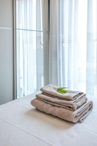 a pile of towels sitting on a table in front of a window at Maria's Deluxe Apartments in Iraklitsa