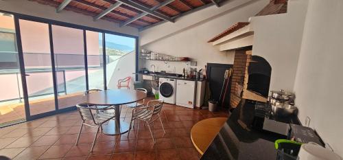 a kitchen with a table and chairs in a room at Peaceful Valley house in Câmara de Lobos