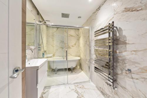Un baño con ducha, bañera y lavabo. en Richmond Riverside Villa, en Richmond