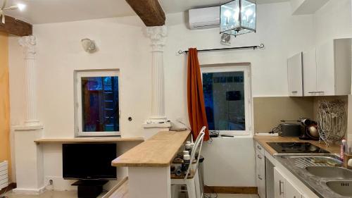 une cuisine avec des armoires blanches et un comptoir dans l'établissement Charmant appartement au calme sur jardin, à Saint-Brice-sous-Forêt