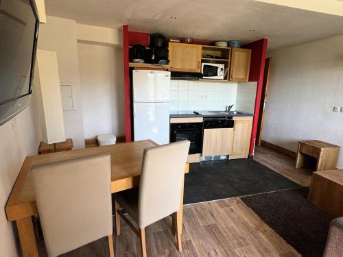 une petite cuisine avec une table et un réfrigérateur dans l'établissement Résidence Le Centaure - Studio pour 4 Personnes 721, à Aime La Plagne