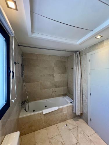 a large bathroom with a tub and a shower at SEAVIEW Luxury PENTHOUSE in Casares