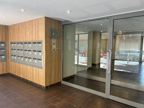 un hall d'entrée avec des portes vitrées et une voiture dans un parking dans l'établissement Charmant T3 proche gare et plages Toulon PARKING PRIVÉ, à Toulon