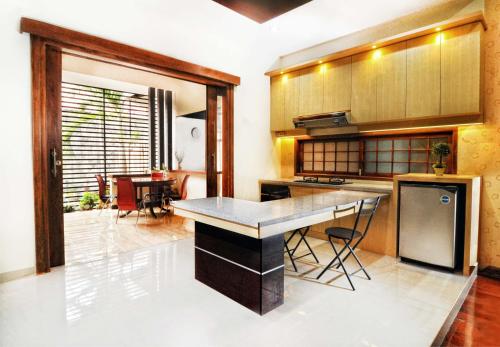 a kitchen with a island in the middle of a room at Batikan de Ville House in Yogyakarta