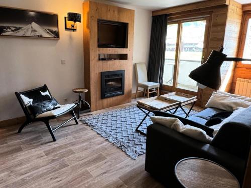 un salon avec un canapé et une cheminée dans l'établissement Résidence Le Centaure - 4 Pièces pour 8 Personnes 561, à Aime La Plagne