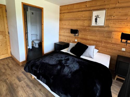 - une chambre avec un lit et un mur en bois dans l'établissement Résidence Le Centaure - 4 Pièces pour 8 Personnes 561, à Aime La Plagne