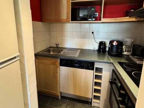 Il comprend une petite cuisine équipée d'un évier et d'un lave-vaisselle. dans l'établissement Résidence Le Centaure - 2 Pièces pour 4 Personnes 681, à Aime La Plagne