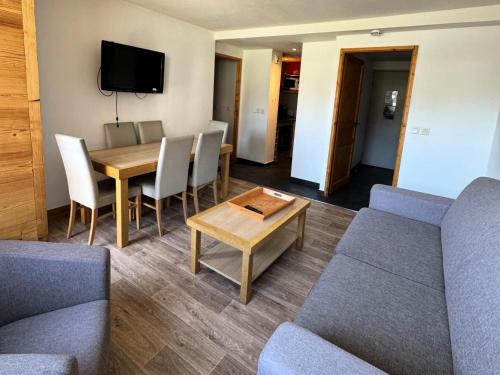 un salon avec un canapé, une table et des chaises dans l'établissement Résidence Le Centaure - 2 Pièces pour 4 Personnes 691, à Aime La Plagne