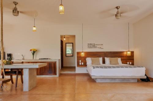 a bedroom with a bed and a table in it at Casa Mosaicos - Adults only in Puerto Escondido