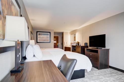 a hotel room with a bed and a flat screen tv at Holiday Inn West Yellowstone by IHG in West Yellowstone