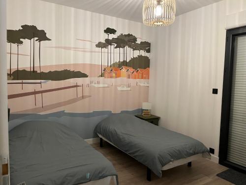 une chambre avec un lit et un tableau au mur dans l'établissement Villa Marylka - une cabane au Pyla, à La Teste-de-Buch