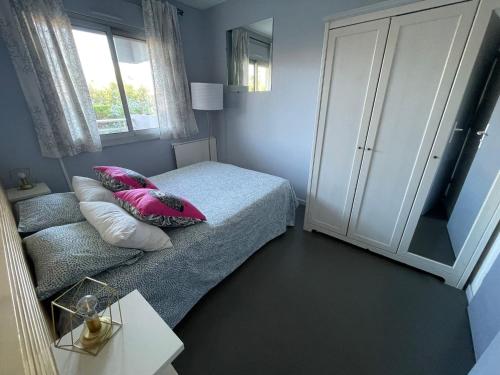 - une chambre avec un lit doté d'oreillers roses et d'une armoire dans l'établissement Home Sweet Home, à Antibes