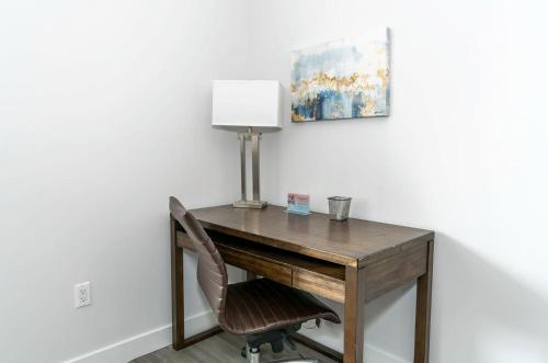 a wooden desk with a chair and a lamp at Luxury Apt with Rooftop in New Rochelle