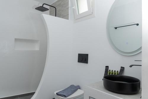 a bathroom with a black sink and a mirror at Allegro seasight appartment in Livadi Astypalaias