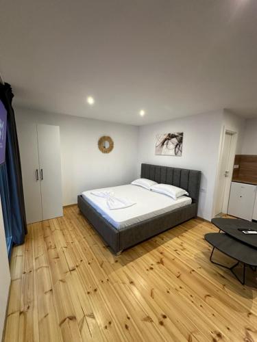 a bedroom with a bed and a wooden floor at Lake Escape Villa Shirokë in Shkodër