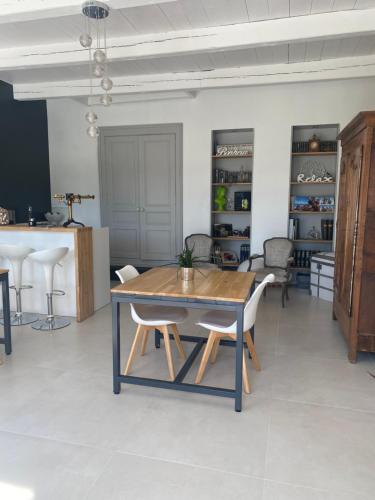 a dining room with a wooden table and chairs at La Chaumeauniere in Aigrefeuille-dʼAunis