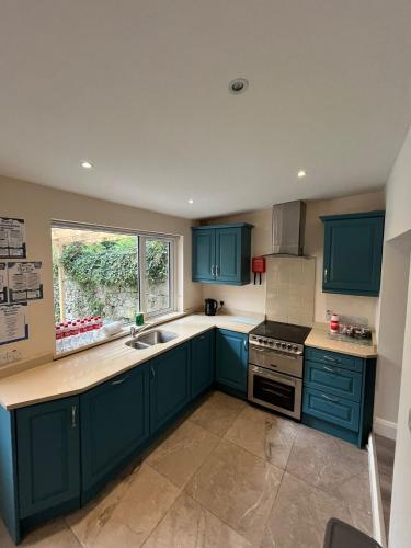 a kitchen with blue cabinets and a sink and a window at 6 Eyre Square Lane in Galway