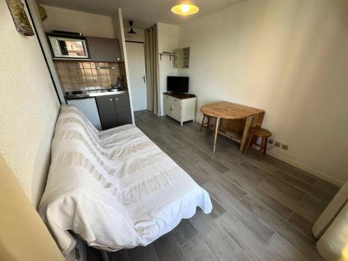 une petite pièce avec un lit et une table dans l'établissement Résidence Cap Vert - Coquet T2 front de mer dans domaine avec piscine et tennis MAE-5634, à Six-Fours-les-Plages