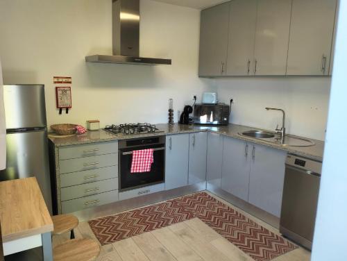 a kitchen with white cabinets and a stove top oven at CASA NOVA MONTALEGRE in Montalegre