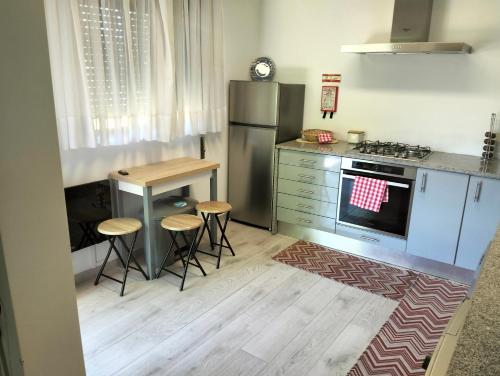 a kitchen with a refrigerator and a table and stools at CASA NOVA MONTALEGRE in Montalegre